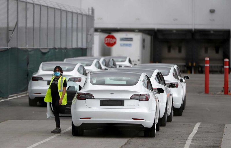 A worker exits a Tesla Model 3 electric vehicle at Tesla's primary vehicle factory n Fremont, California, U.S. May 11, 2020. REUTERS/Stephen Lam/File Photo