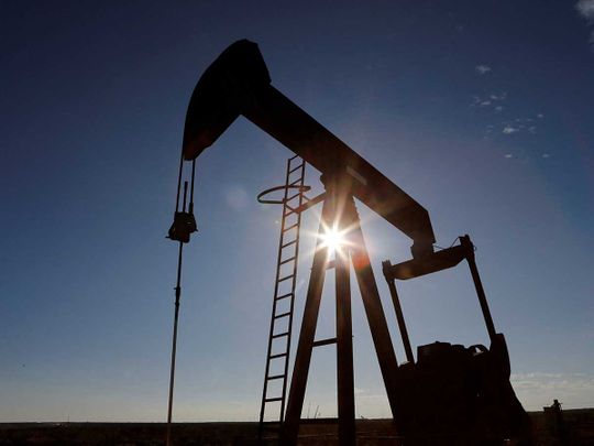 The sun is seen behind a crude oil pump jack in the Permian Basin US