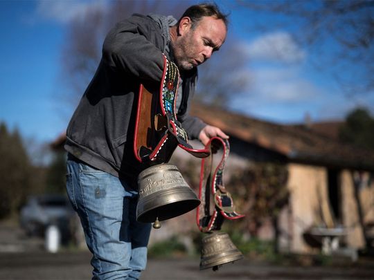 Farmer Rolf Rohrbach (L) poses with cow bells used during transhumance in the village of Aarwangen, central Switzerland, on November 29, 2023. Photograph:(AFP)