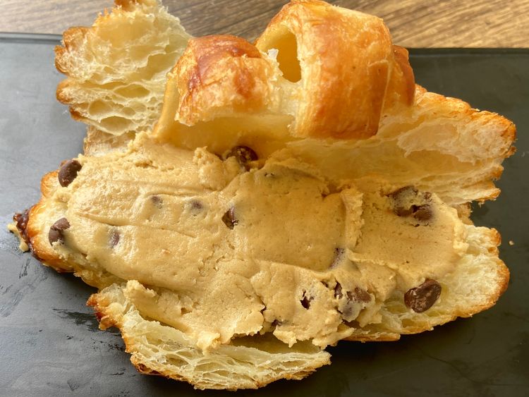 Split the croissant in half horizontally and fill each half with 2 tablespoons of cookie dough, spreading it evenly with a spatula.